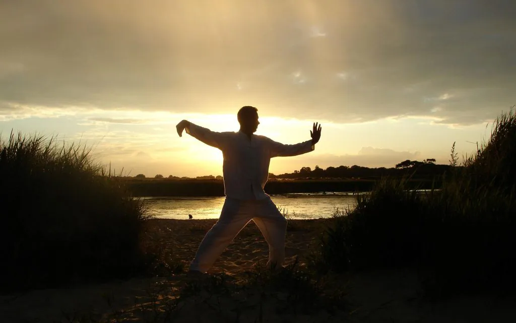 Person practicing tai chi at sunset